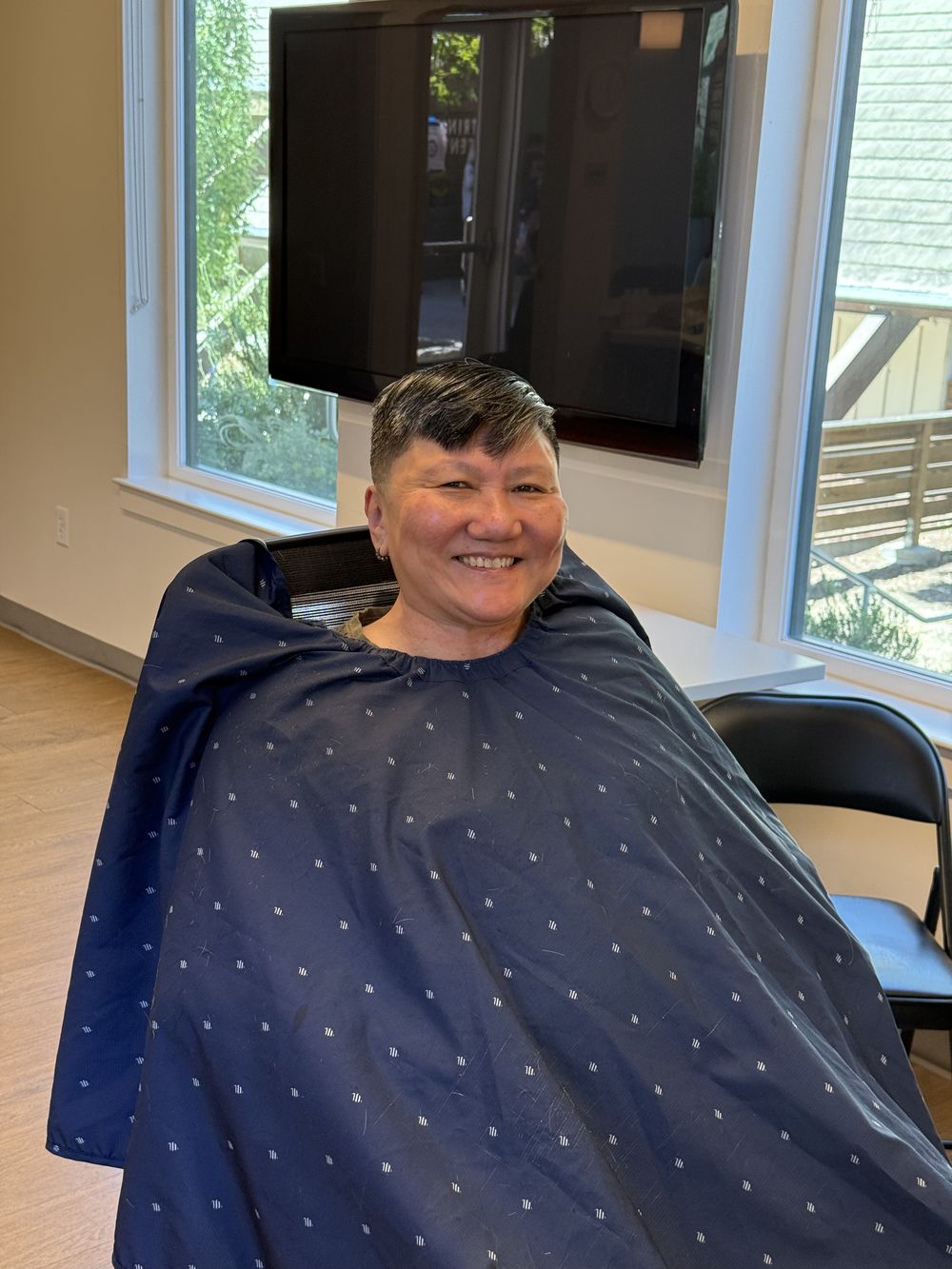 A community member smiling with her new haircut after the free haircut event.